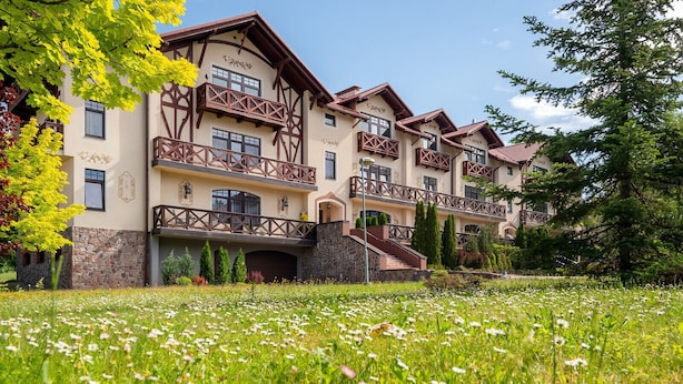 A multi-story building with a traditional architectural style, featuring balconies and a stone facade. - Beautiful, cozy, family-friendly apartment in the middle of nature. (Sigulda)