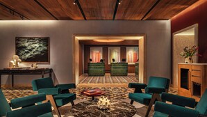 Un salón moderno con sillones color turquesa, una mesa de centro de mármol y un suelo con diseño.