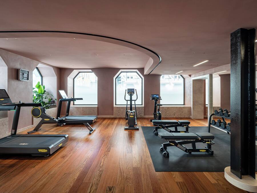 A modern gym with treadmills, weight machines, and dumbbells.