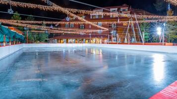 An ice skating rink with a building in the background.