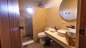 Une salle de bain avec des toilettes, un lavabo et un miroir.