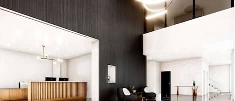 Un área de recepción moderna con un mostrador de madera, asientos negros y piso de mármol.