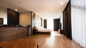 A modern hotel room with a large bed, a wooden table, and a seating area. - Radisson San Luis Potosi Aeropuerto (San Luis Potosi)