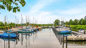 Een jachthaven met diverse boten die aan de waterkant liggen.