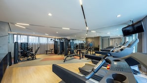 A modern gym with treadmills, weight machines, and a mirror wall.