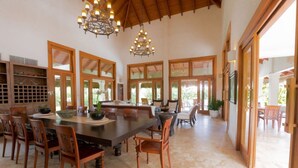 A spacious dining area with a large table, wooden chairs, and a chandelier. - Escape to Lagunas 2, a serene villa in Cap Cana, perfect for families or groups (Punta Cana)