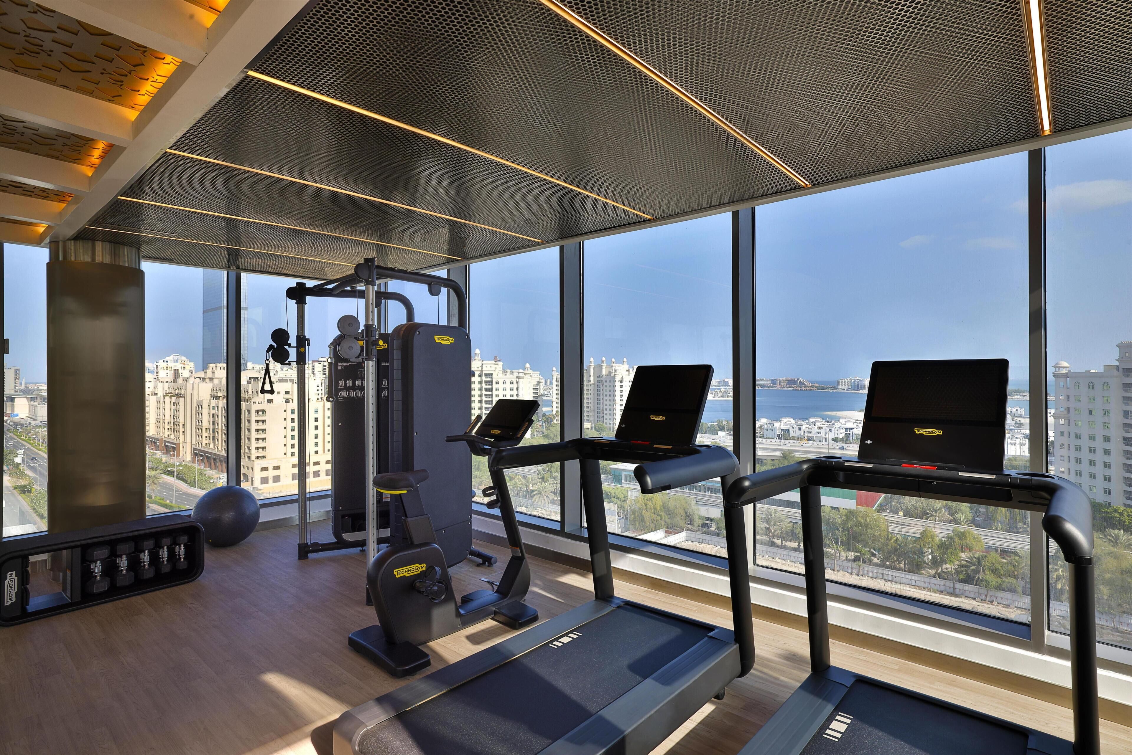 A gym with treadmills, a weight machine, and a rowing machine.