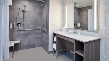 A modern bathroom with a shower, toilet, and vanity.