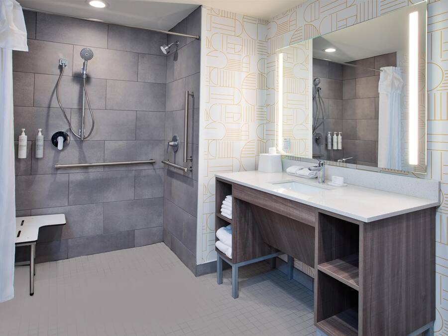 A modern bathroom with a shower, toilet, and vanity.