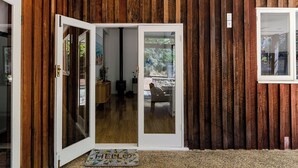 A wooden interior with a sliding glass door leading to a living area.
