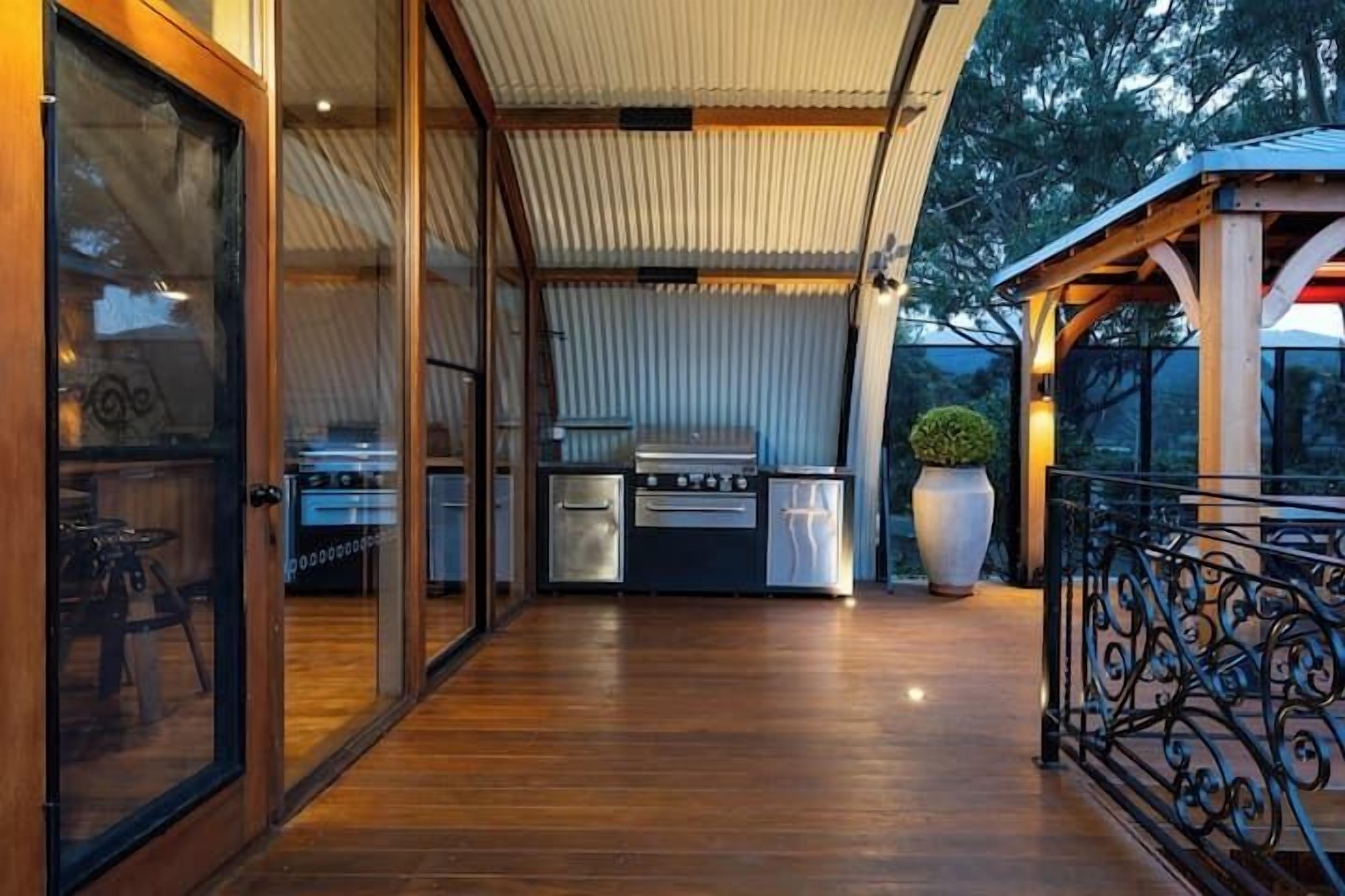 An outdoor kitchen area with a grill, oven, and sink.