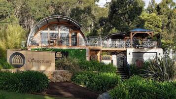 A building with a sign reading "Sanctuary" and a covered outdoor area with a railing.