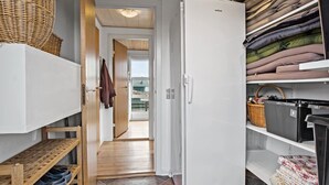 A narrow hallway with a white refrigerator, wooden shelves, and a wicker basket. - Awesome home in Ebberup with WiFi (Ebberup)