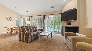 A living room with a sofa, armchair, coffee table, and a fireplace. - Creekside Condo w/ Pool & Beach Club #118 (Bellaire)