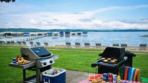 An outdoor grilling area with a view of a lake and docked boats. - Creekside Condo w/ Pool & Beach Club #118 (Bellaire)