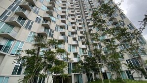 A high-rise residential building with multiple balconies and a modern architectural design.