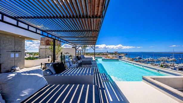 Piscina no terraço com vista para a marina e o oceano.