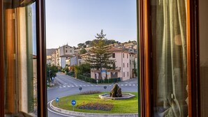 Une vue depuis une fenêtre d’un immeuble, avec un rond-point, une fontaine et des immeubles d’habitation en arrière-plan.