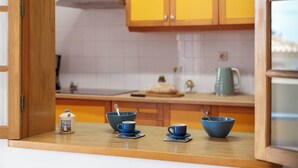 A kitchen with wooden cabinets, a countertop, and three blue cups on saucers.