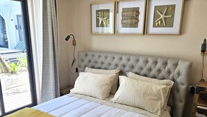 A bedroom with a large bed, a yellow throw blanket, and framed artwork on the wall. - Walking distance to several beaches, Ferragudo village, supermarkets and Portimão,  (Ferragudo)