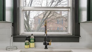 Una cocina con un lavamanos de acero inoxidable, un grifo y dos botellas de jabón Ever Spring sobre la encimera.