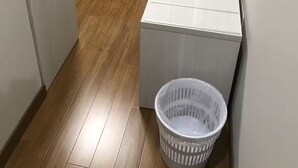 A small, compact room with a bed, a small desk, and a laundry basket. - Basic Double Room (Bari)