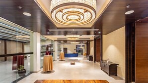 A modern hotel lobby with a polished wooden floor, a reception desk, and a large circular chandelier. - Ramada by Wyndham Kathmandu Dhumbarahi (Kathmandu)