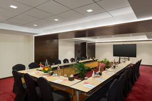 A conference room with a long table, chairs, a projector screen, and a red carpet. - Ramada by Wyndham Kathmandu Dhumbarahi (Kathmandu)