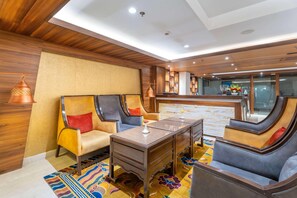 A modern hotel room with wooden paneling, a central desk, and comfortable seating. - Ramada by Wyndham Kathmandu Dhumbarahi (Kathmandu)