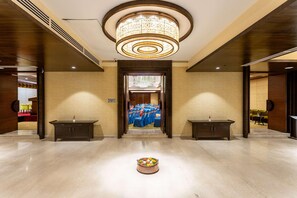 A hotel lobby with a central chandelier, two side tables, and a buffet table in the middle. - Ramada by Wyndham Kathmandu Dhumbarahi (Kathmandu)