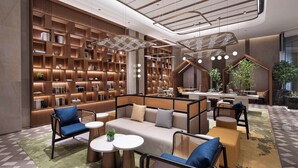 Un interior moderno con una amplia estantería, zonas de estar y un diseño de techo singular.