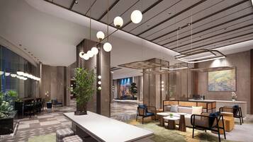 A modern hotel lobby with a reception desk, seating areas, and a large abstract painting on the wall.