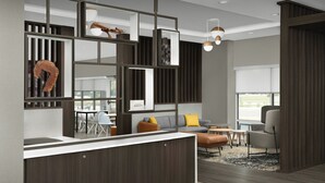 Un interior moderno con una cocina central, una zona de estar con sofá y sillones, y un amplio ventanal que proporciona luz natural.
