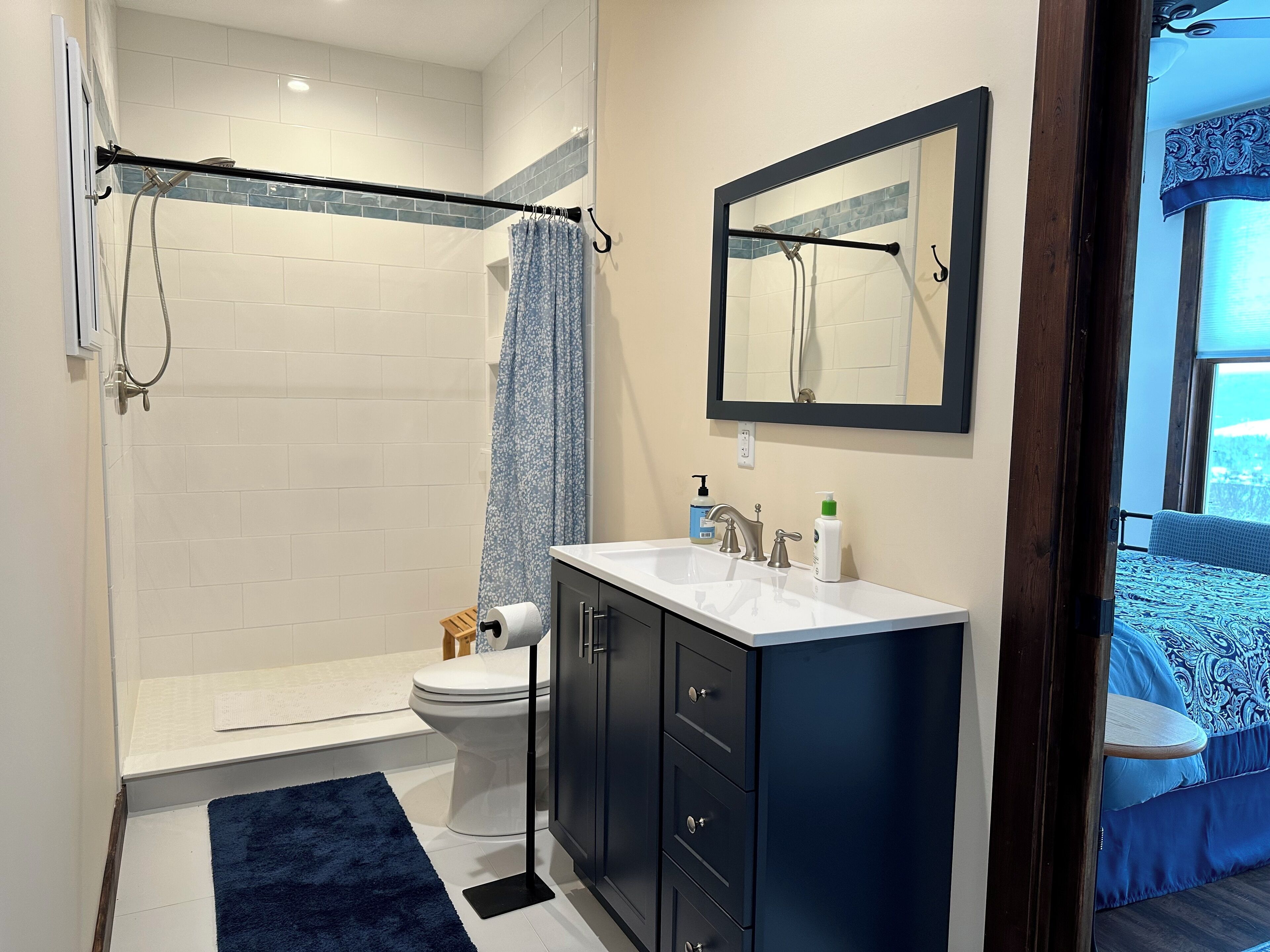 A bathroom with a shower, toilet, and sink.
