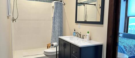A bathroom with a shower, toilet, and sink.