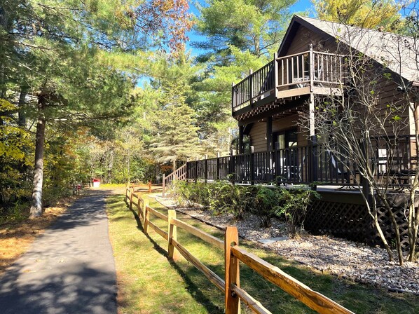 A lodge with a wooden exterior, a balcony, and a pathway leading to it.