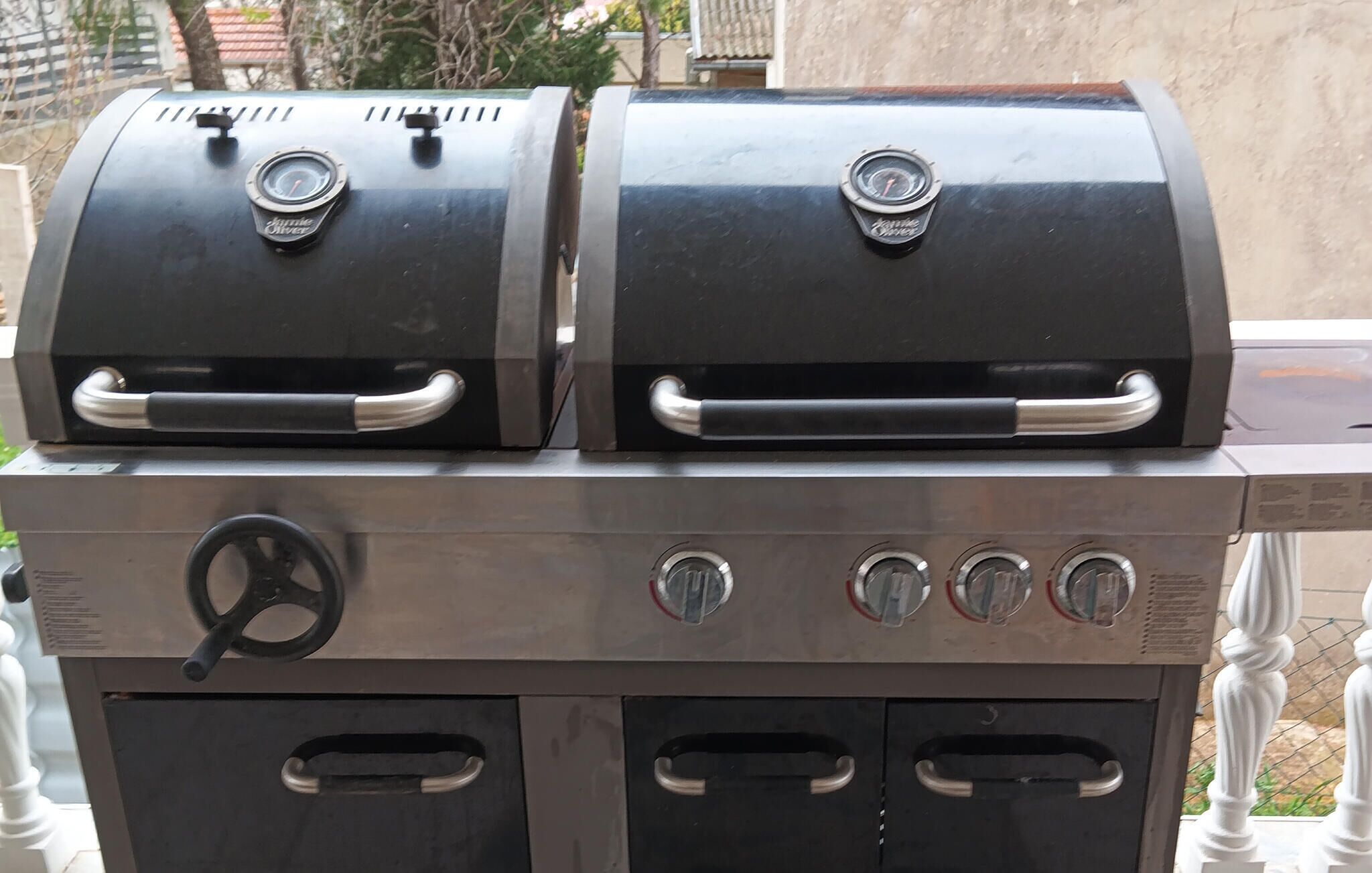 Un barbecue à gaz à deux brûleurs, doté d’une finition en acier inoxydable et d’un panneau de commande avec quatre boutons.