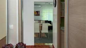 A modern interior with a dining area, a sofa, and a kitchen in the background. - Cozy apartment in Gornji Karin with WiFi (Gornji Karin)