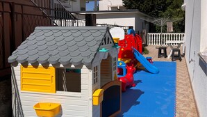 A children's play area with a slide, climbing structures, and a small house with a window and door. - Cozy apartment in Gornji Karin with WiFi (Gornji Karin)