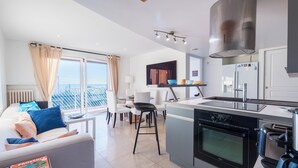 Een moderne keuken met een inbouwoven en een eethoek met een tafel en stoelen.