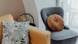 En moderne stue med en sofa, en lænestol og en lampe.