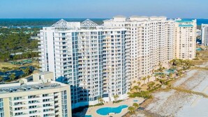 A high-rise hotel with multiple balconies, a pool area, and a beach view. - Palacio 902 | Beachfront & Resort Amenities | My Beach Getaways (Pensacola)