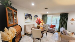 A living room with a dining area, a wooden cabinet, and a sofa. - The BlueStone-Stylish 3BR in Central Abilene (Abilene)