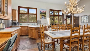 Una cocina amplia con armarios de madera, una isla grande y un comedor con sillas y mesa de madera.