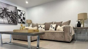Ein modernes Wohnzimmer mit einer Couch, einem Couchtisch und zwei Lampen.