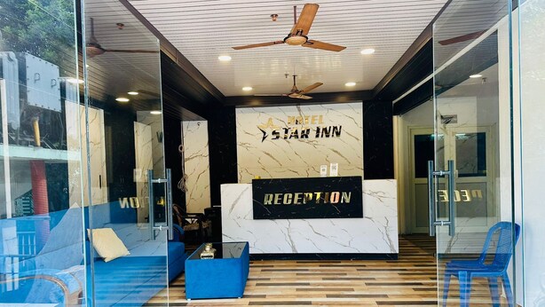 A modern hotel lobby with a reception desk, seating area, and a ceiling fan. - Hotel Star Inn (Visakhapatnam)