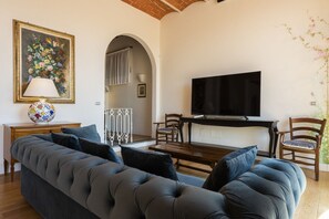 A living room with a sofa, TV, and a painting. - Villa Yvonne by MMega (Signa)