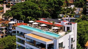 A modern hotel with a rooftop pool, multiple balconies, and lush greenery surrounding the property. - Chic Penthouse Ocean Views, Rooftop Pool & Balcony (Puerto Vallarta)