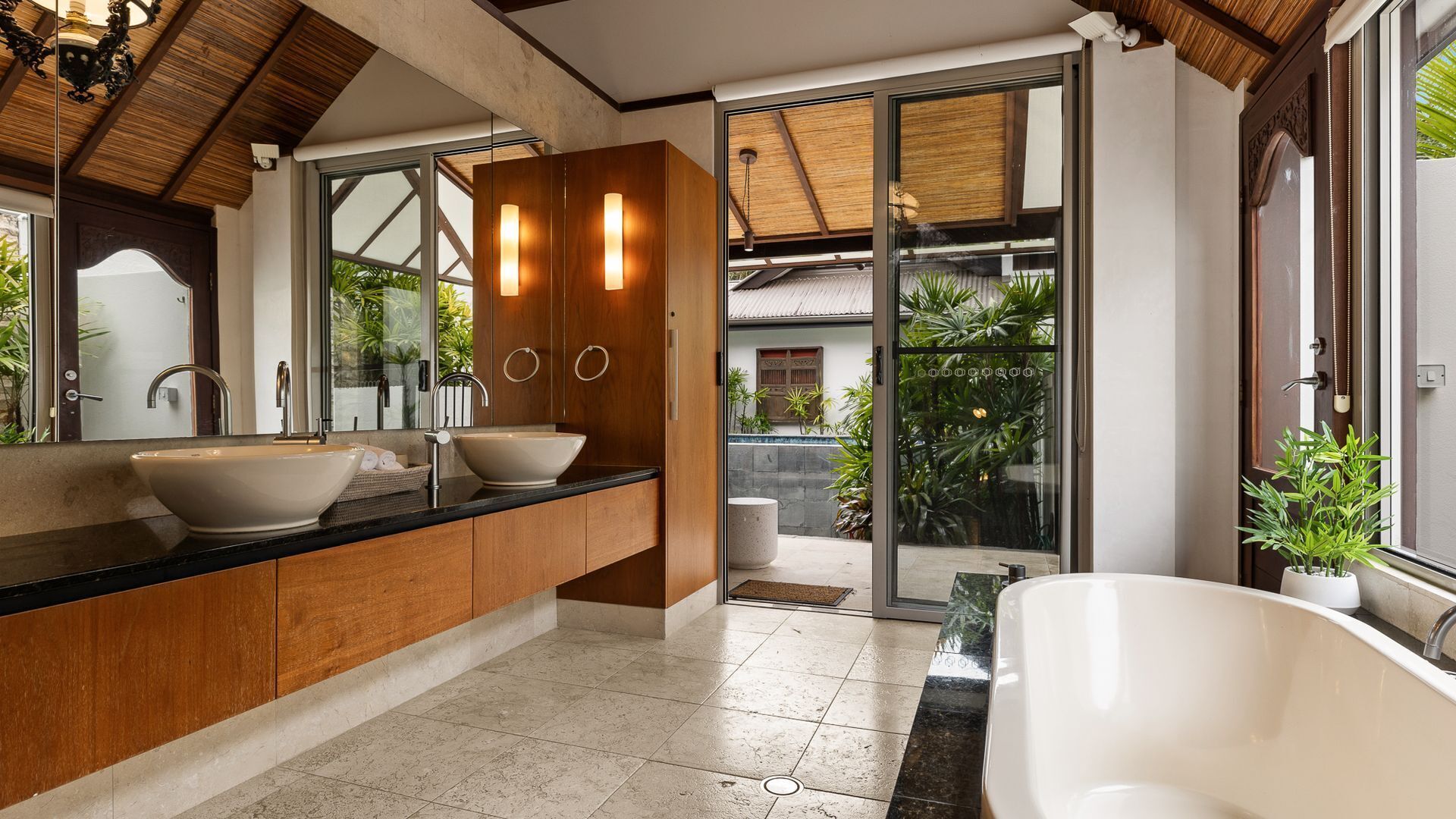 Ein modernes Badezimmer mit einer großen Badewanne, zwei Waschbecken und einer gläsernen Duschkabine.