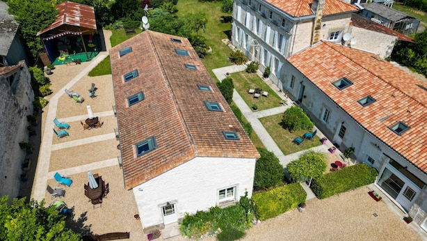 En innergård med en vit byggnad, en byggnad med rött tak och en modern byggnad med stora fönster.